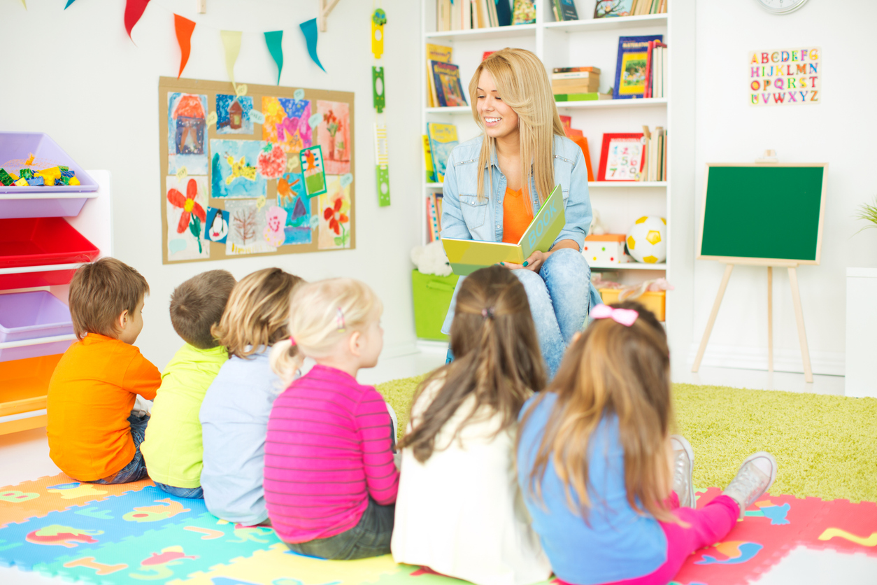 Teacher reading a book to children