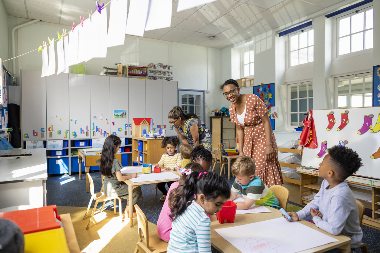 Teachers helping children with their drawings