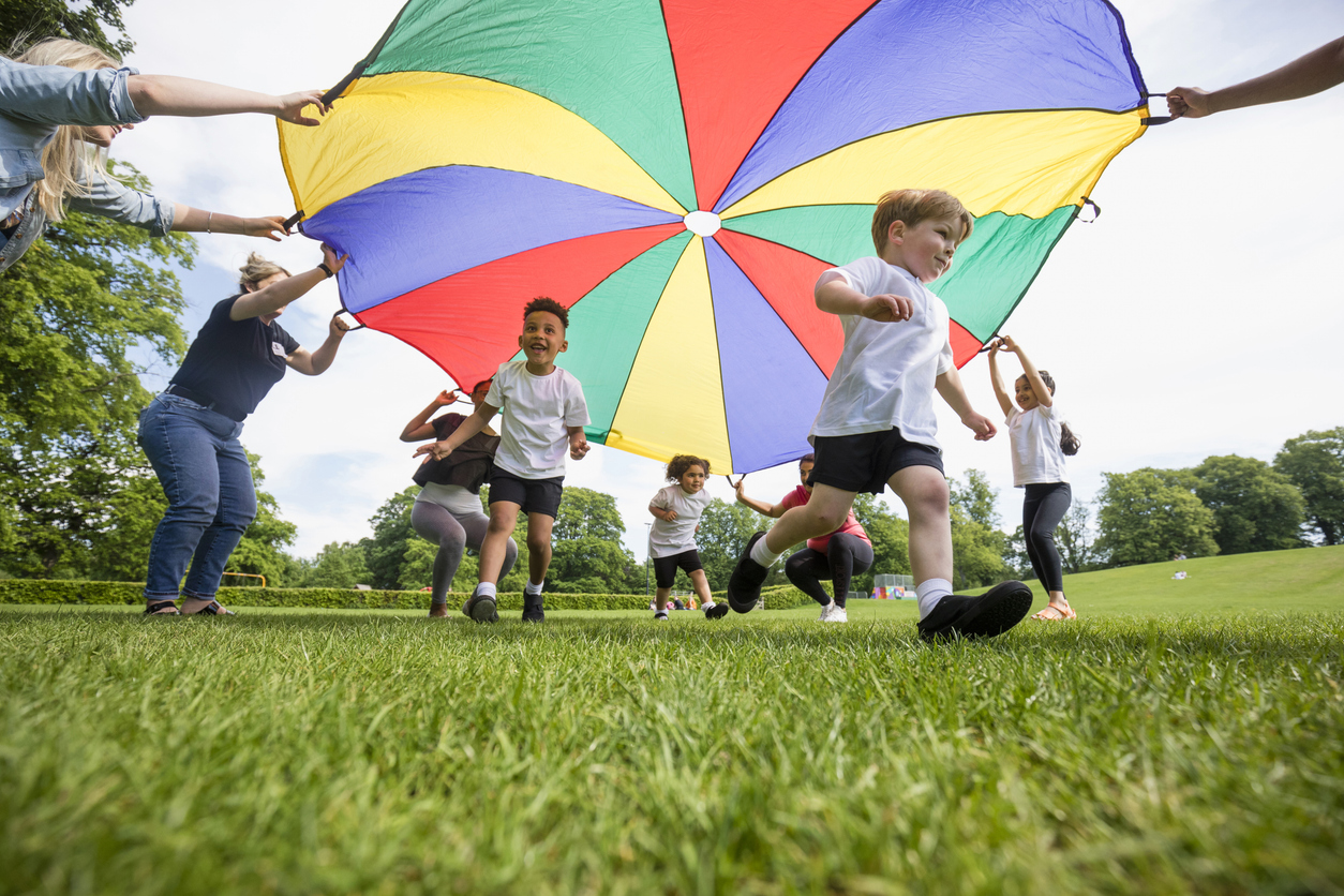 Children running under a parachute