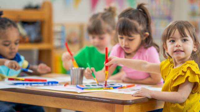 Children painting around table